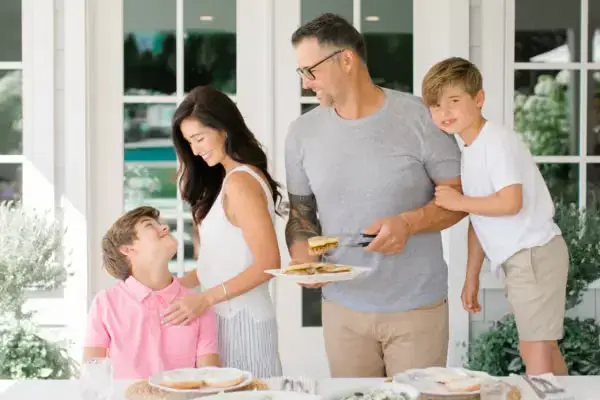 A family serving dinner together at an outdoor table